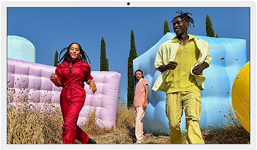 Three people in bright outfits, surrounded by colourful inflatable shapes