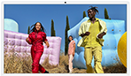 Three people in bright outfits, surrounded by colourful inflatable shapes