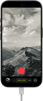 iPhone 18 Pro, front exterior, displaying a mountainous landscape, with the camera mode overlay in Time-Lapse mode, with charging cable attached to charging port