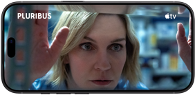 iPhone 18 Pro, landscape mode, displaying a close-up of a woman looking through shelves. Series title: Pluribus