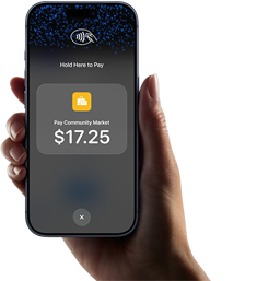 Right hand holding iPhone with display showing specific amount to be paid and instructions on how to contactlessly pay when ready